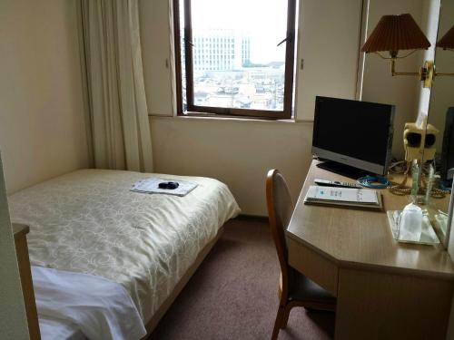 a hotel room with a desk with a computer on it at Uwajima Regent Hotel in Uwajima