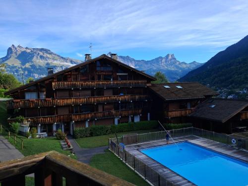 un hôtel avec une piscine et des montagnes en arrière-plan dans l'établissement Au coeur des Alpes, à Saint-Gervais-les-Bains