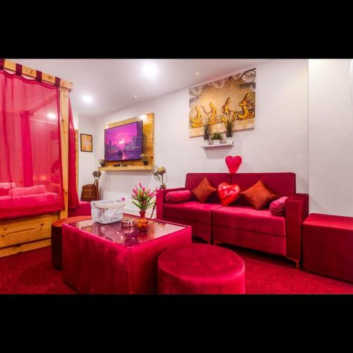 a living room with red couches and a table at Pink Hawk Hospitality in Hyderabad