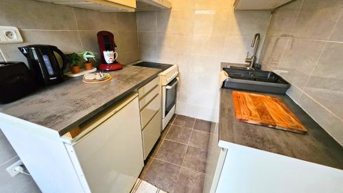 une petite cuisine avec un évier et une cuisinière dans l'établissement Mamie Jeanne Arcueil près RER B SIEC, à Arcueil