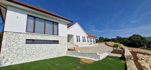 a white house with a stone facade at Villa Zéta Wine & Spa in Mád
