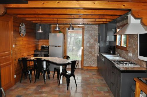 une cuisine avec une table, des chaises et un réfrigérateur dans l'établissement Chalet Eras, Belle vue lac, Sauna, Wifi, à Gérardmer