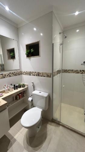 a bathroom with a white toilet and a shower at Descanso e Tranquilidade em Guaratiba in Rio de Janeiro