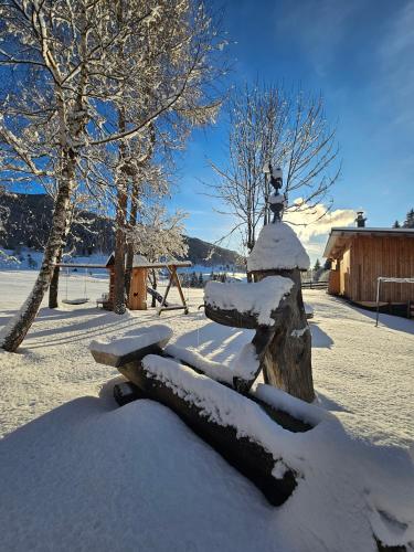 a bench covered in snow in a park at Landhotel Lacknerhof in Mariapfarr