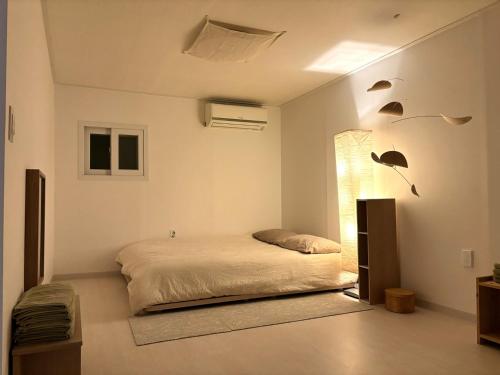 ソウルにあるIchon Green Tea Houseのベッドルーム1室(ベッド1台付)が備わります。壁には鳥がいます。