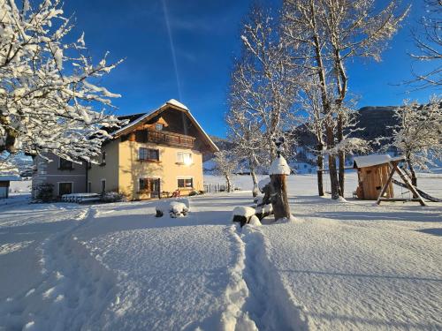 a snow covered yard with a house in the background at Landhotel Lacknerhof in Mariapfarr