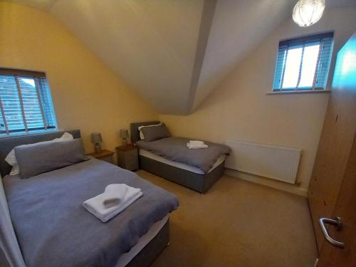 a bedroom with two beds and two windows at Cosy Spacious 2 bedroom Apartment Free Parking in Nottingham