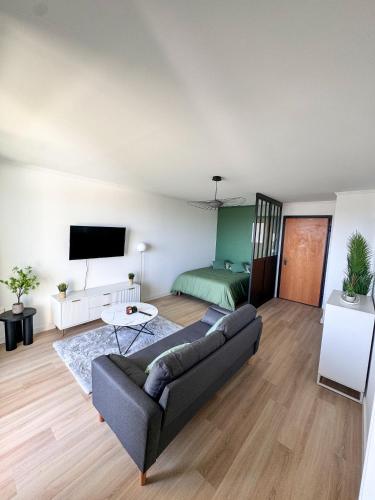 una sala de estar con un sofá y una cama en La Verrière, en Saint-Denis