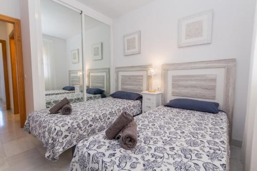 a bedroom with two beds and a mirror at Winter Deal - Luxury Apartment with Terrace Mountain Views Near Beach in Fuengirola