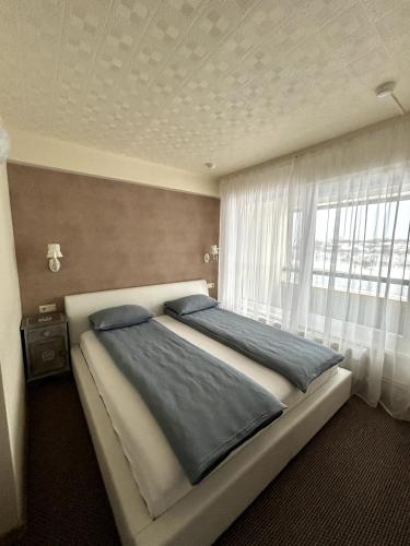 a bedroom with a large bed with a window at Hotel Talsi in Talsi