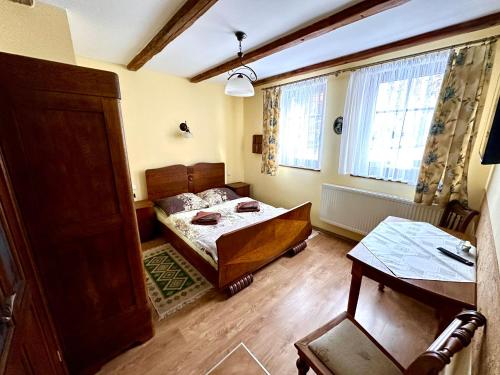 a small bedroom with a bed and a table at Kwatery Prywatne-Willa "Nadzieja" in Świeradów-Zdrój