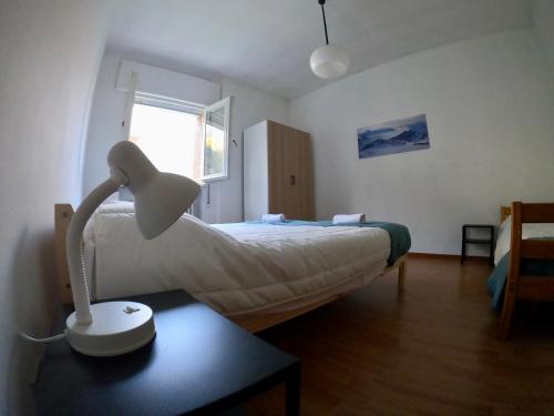 a bedroom with a bed with a lamp on a table at Casa Cavour - vicino Tarvisio e Nassfeld in Pontebba
