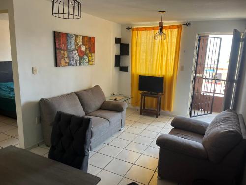 a living room with a couch and a tv at Departamento Entero en el Sur Facturamod in Santa Gertrudis