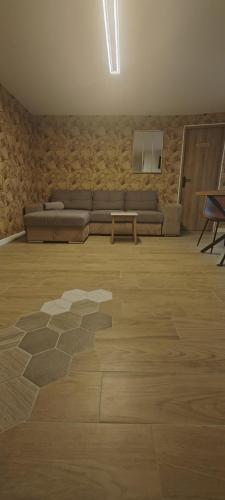 a living room with a couch and a table at Bel Appartement moderne in LʼHôpital