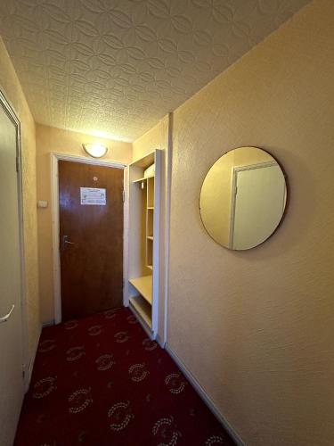a hallway with a mirror and a door with a red carpet at Hotel Talsi in Talsi