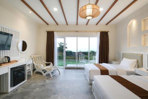 a hotel room with two beds and a television at Flamingo Aquila in Badung