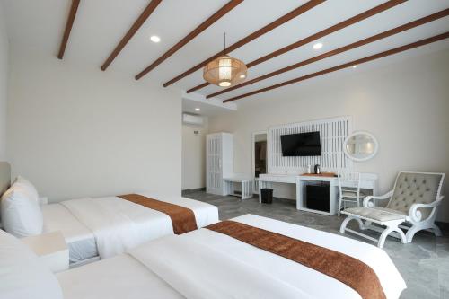 a hotel room with two beds and a tv at Flamingo Aquila in Badung