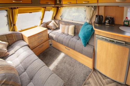 an interior of an rv with couches and a kitchen at Skye-Fall in Drumfearn
