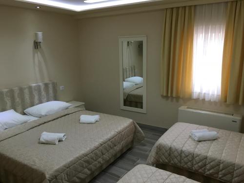a hotel room with two beds and a mirror at Boutique Hotel Sulić in Međugorje