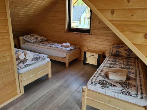 a room with two beds in a log cabin at Domek u Julii in Krościenko