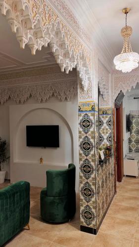 a living room with a green chair and a tv at Appartement near to AirPort 262 avenue el khalij 2 BEDROOM in Marrakech