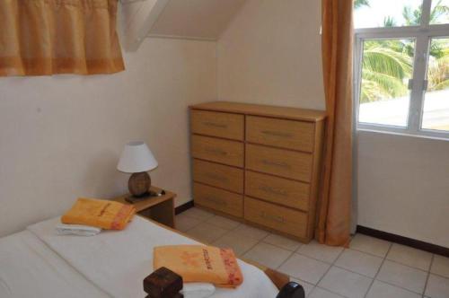 a bedroom with a bed and a dresser and a window at Villas Right ON the Beach Belle Mare in Belle Mare