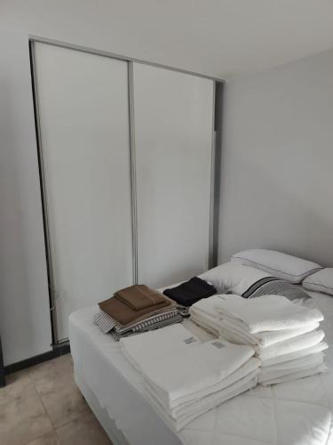 a white bed with a pile of books on it at Villa Lastenia in San Salvador de Jujuy