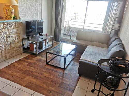 un salon avec un canapé et une table en verre dans l'établissement Canet-Beach, à Canet
