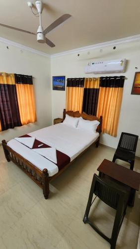 Un dormitorio con una cama, una silla y una mesa. en New Seiko The Homestead, en Alleppey