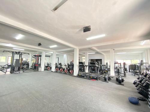 a gym with several treadmills and machines in it at Amelia Aparthotel in Buea