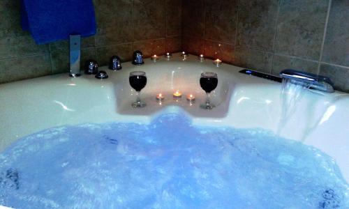 a tub with two wine glasses and candles in it at Villa Alexandros in Zóla