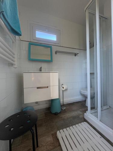 La salle de bains est pourvue d'un lavabo, de toilettes et d'une chaise. dans l'établissement Le Club des Cigales, à Hyères