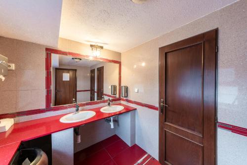 a bathroom with two sinks and a brown door at Botel Albatros in Prague