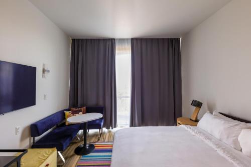 a hotel room with a bed and a table and a window at Aloft Ponce Hotel & Casino in Ponce