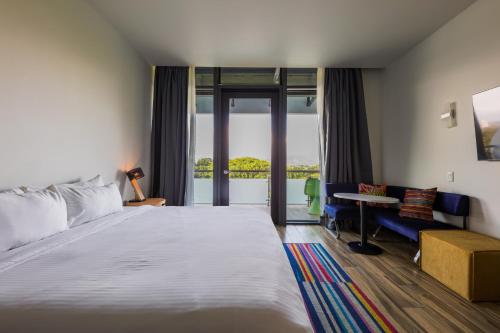 a hotel room with a large bed and a desk at Aloft Ponce Hotel & Casino in Ponce