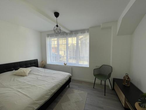 une chambre avec un lit, une chaise et une fenêtre dans l'établissement Appartement moderne, à Montrichard
