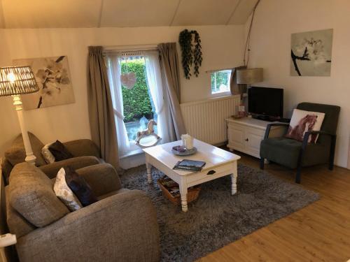 a living room with a couch and a coffee table at B&B Schoonloo - boerderij appartementen in Schoonloo