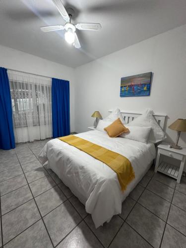 a bedroom with a large bed and a ceiling fan at La Same Homestead in Margate