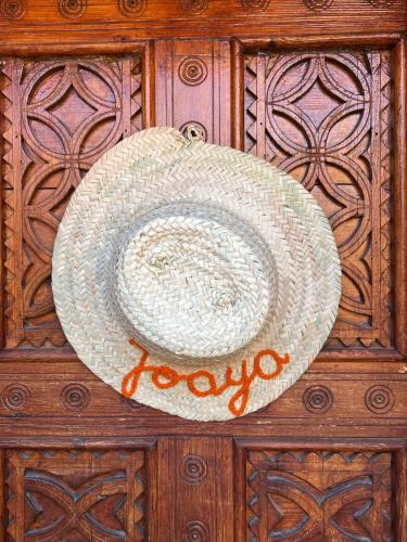 a straw hat on top of a wooden wall at Riad Beldi by MaHa in Oulad Teima
