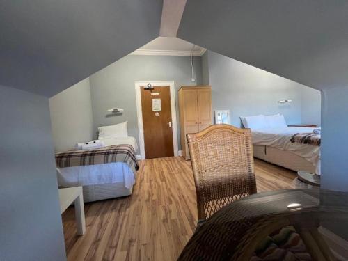 a room with two beds and a chair in it at Gothenburg Hotel in Rosyth