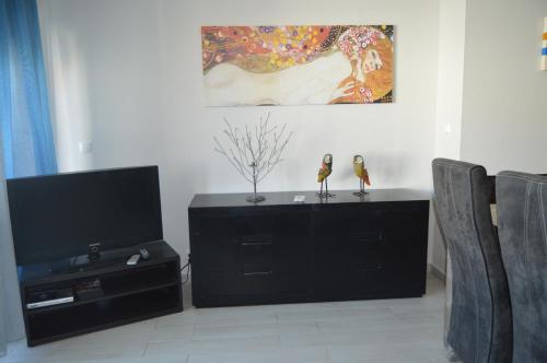 a living room with a tv and a black entertainment center at Manta Rota Beach Haven in Vila Nova De Cacela