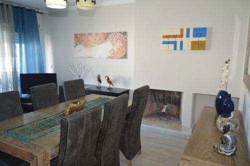 a dining room with a table and chairs and a fireplace at Manta Rota Beach Haven in Vila Nova De Cacela