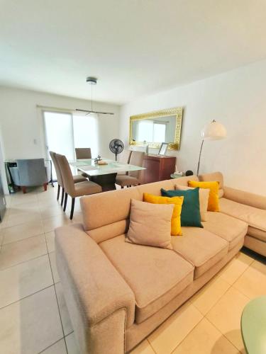 a living room with a brown couch with yellow pillows at NUEVA Hermosa casa vía Samborondón Coliving Ecuador in Guayaquil