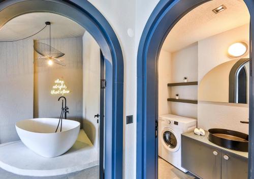 a bathroom with a tub and a washing machine at Nodus Tollens Apart in Kaş