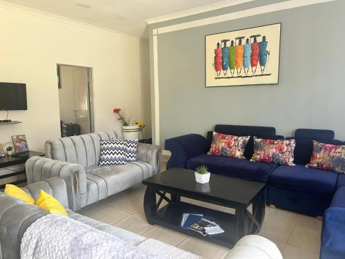a living room with couches and a coffee table at KareBer Deluxe - Gulu - Uganda in Gulu