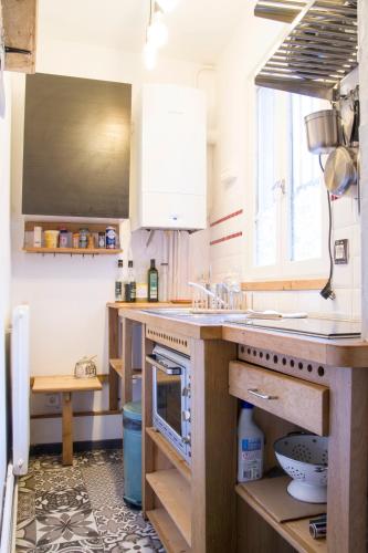 une cuisine avec des armoires blanches et un comptoir dans l'établissement L'air du temps - Centre historique Wifi TV, à Besançon