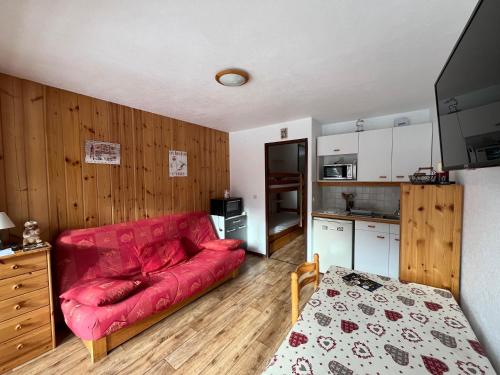 un salon avec un canapé rouge et une cuisine dans l'établissement Appartement Valloire Galibier 4 personnes pied de piste, à Valloire