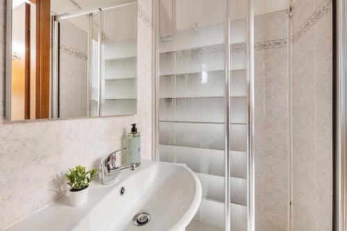 Un baño blanco con lavabo y espejo. en White Flat Sanniti, en Roma