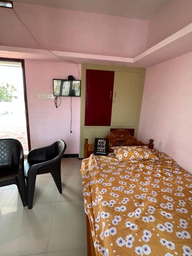 a bedroom with a bed and a chair and a window at PM COTTAGE-2nd FLOOR-NON AC ROOM WITH GREEN NATURAL VENTILATION ONLY FOR PILGRIMS ,FAMILY OR BACHLOR in Suchindram