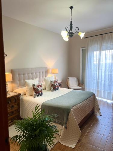 a bedroom with a large bed and a chandelier at Casa Rural Abril in Setenil